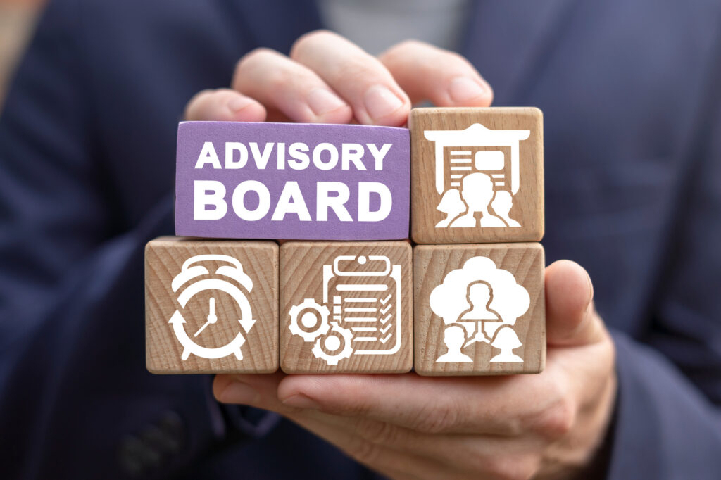 Advisory board concept shown with wooden blocks and icons representing collaboration and decision-making