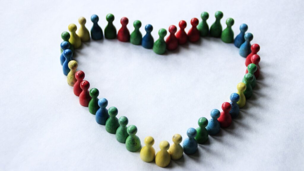 Colorful Ludo game pieces arranged in a heart shape.