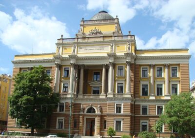 Historic main building of the University of Sarajevo with classical architecture and columns under a blue sky
